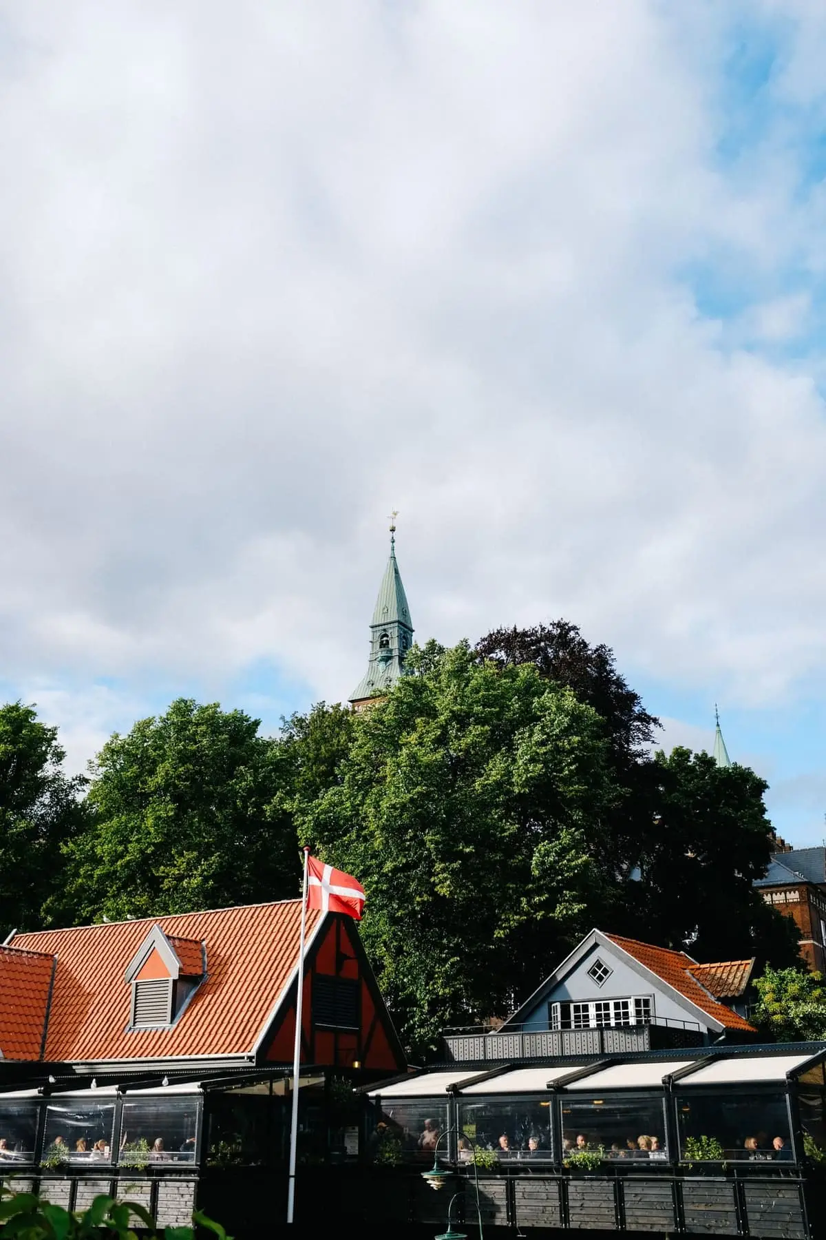 Dansk landsby med huse og kirketårn bag træerne